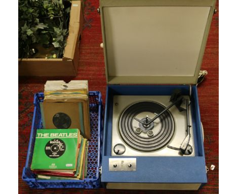 A vintage 1960s record player and collection of singles to include The Beatles and Elvis Presley etc.