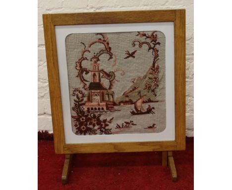 An oak folding firescreen/occasional table with woolwork tapestry depicting a chinoiserie landscape.