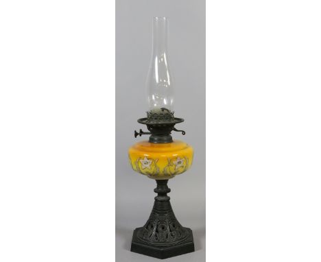 A Victorian pierced cast iron based oil lamp with coloured and painted glass font.