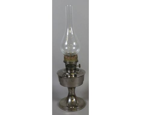 A chrome based oil lamp and glass chimney.