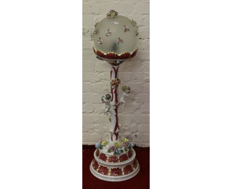 A Capodimonte standard lamp decorated with applied cherubs and flowers.