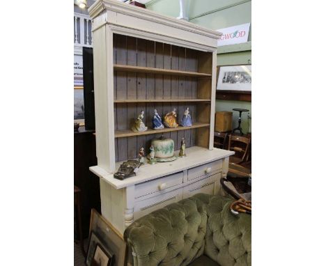 A cream painted kitchen dresser, with triple shelved shelf rack back. Two inline drawers over two cupboard doors.&nbsp;