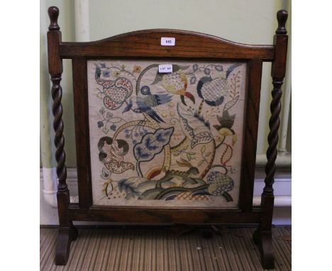 An oak framed tapestry fire screen on barley twist supports. 67cm wide.
