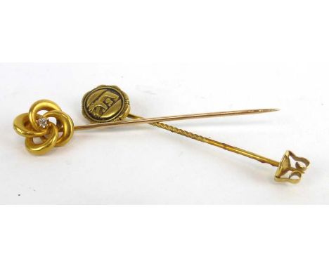 A 14ct yellow gold stick pin set small diamond in a knot setting, together with a further commemorative stick pin (2)