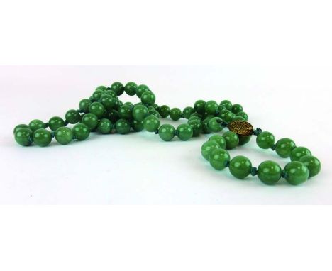 A single strand continuous green jade bead necklace with silver gilt clasp, l. 112 cm, d. of beads approx. 1.2 cm