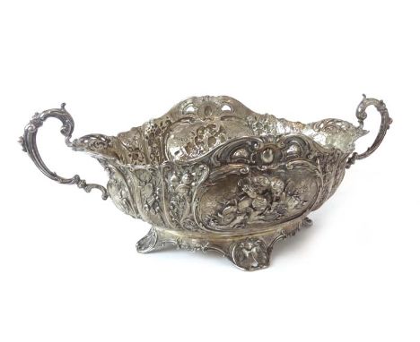 A late 19th century German metalware two handled bowl of oval form, repousse decorated with putti playing musical instruments