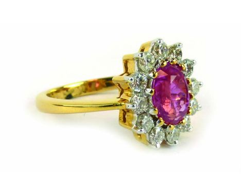 A yellow metal ring set oval Burmese ruby within a border of twelve small diamonds,ring size N,5.8 gms