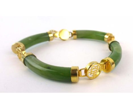 A four section green jade bracelet having gold plated mounts