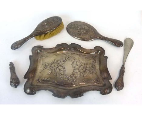 An Edwardian silver dressing table tray repousse decorated with pansies in the Art Nouveau manner, together with four matchin