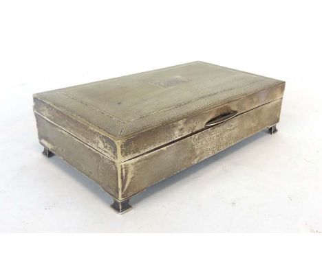A silver engine turned cigarette box of rectangular form on four stepped feet, maker S&M, Birmingham 1963, w. 15 cm CONDITION