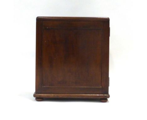 A mahogany box with a panelled door on bun feet, h. 44 cm, containing a set of Inlaid Letter Post scales and weights CONDITIO