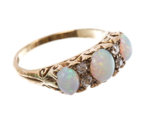 Late Victorian opal and diamond ring with three cabochon opals interspaced by four old cut diamonds with carved gold scroll g