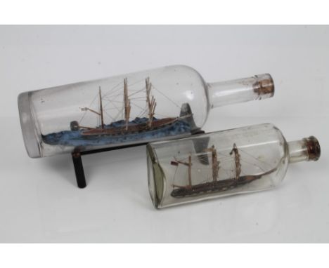 Ship in a bottle, the three-masted ship in clear glass bottle, 31cm wide, on stand, together with a three-masted ship in smal