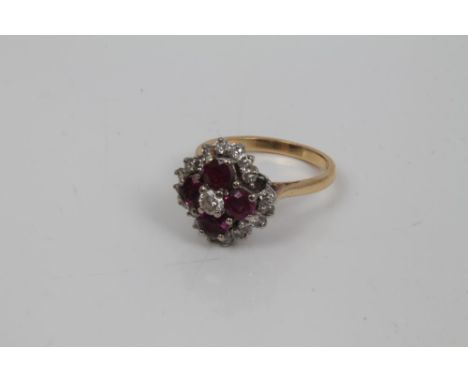 Ruby and diamond cluster cocktail ring with a central brilliant cut diamond, four round mixed cut rubies and a border of bril