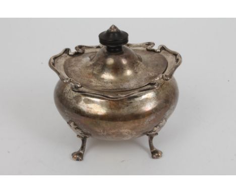 Early 20th century silver tea caddy of compressed baluster form, with flared scroll border and hinged domed cover with turned