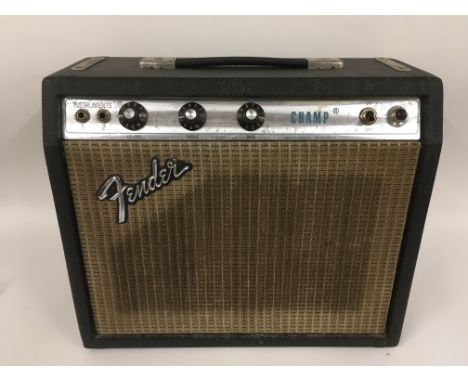 A Fender Champ guitar amplifier with owner's manual and leads.