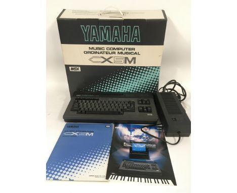 A boxed Yamaha CX5M music computer with original box, owner's manual and power supply.