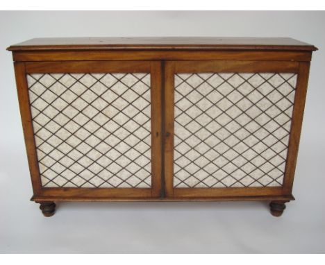 A Regency mahogany low side cabinet, the top with moulded edge above a pair of gilt brass grille mounted cupboard doors enclo
