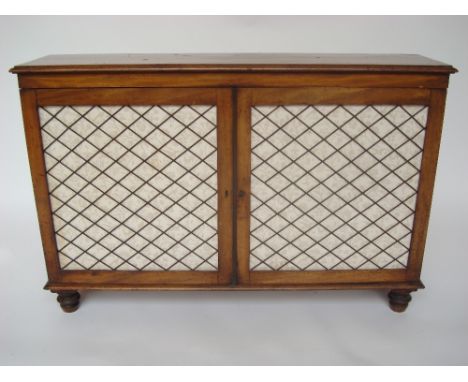 A Regency mahogany low side cabinet, the top with moulded edge above a pair of gilt brass grille mounted cupboard doors enclo