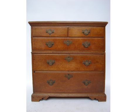 An early 18th Century two section oak chest of drawers, the two plank rectangular top with moulded edge above two short drawe