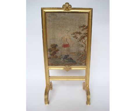 A late Victorian gilt gesso fire screen, with moulded frame, mounted with rectangular woolwork panel, raised on C scroll supp
