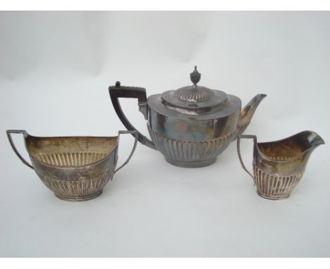 A late Victorian silver three piece tea set, London, 1886 by Edward Hutton, each piece of oval form, half fluted, teapot 26cm