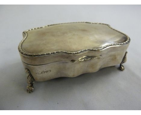 A silver trinket box shaped rectangular, the hinged cover with husk border on four claw feet, Chester 1908