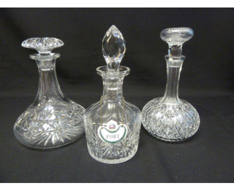 Three cut glass decanters with drop stoppers and a enamel port label