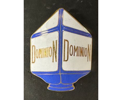 A Dominion (petrol) enamel cap badge in the form of a petrol pump globe by L. Simpson &amp; Co. 55 York Road North London, 2 