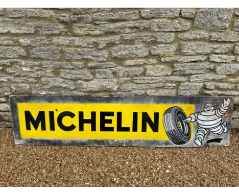 A Michelin (tyres) enamel advertising sign depicting Mr. Bibendum rolling a tyre, 77 x 18 1/4", numbered 79/63/25 (1963).
