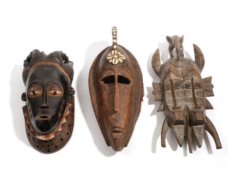 A Senufo Kpeli-Yehe Double Faced Mask, with hornbill headdress, the faces with hobnail type scarifications, 45cm; a Yaure Mas