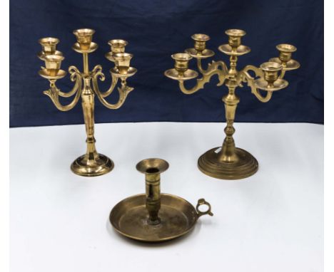 Two brass candelabra and a candle stick