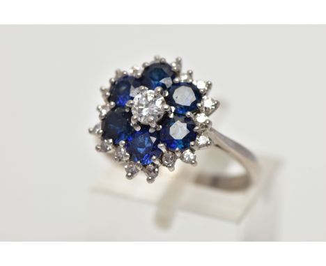 A SAPPHIRE AND DIAMOND CLUSTER RING, set with a principal round brilliant-cut diamond, surrounded by six circular mixed cut s