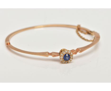 AN EARLY TWENEITH CENTURY GOLD SAPPHIRE AND DIAMOND BANGLE, a yellow gold oval hinged bangle, set with a circular cut bright 