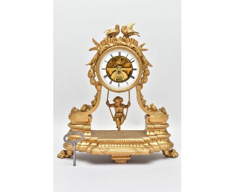 A LATE 19TH CENTURY GILT SPELTER CHERUB ON A SWING MANTEL CLOCK, the drum shaped clock surmounted by two birds , ribbons and 