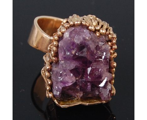 After Andrew Grima, a contemporary 9ct gold amethyst set dress ring, the uncut amethyst geode in a sunken abstract setting to