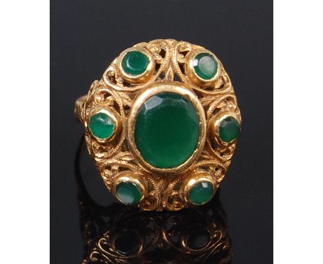 A ladies 18ct gold and emerald set dress ring, arranged as a centre oval cut emerald weighing approx 1.75ct, in a scroll chas