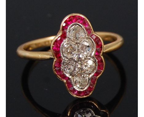 An early 20th century ladies 18ct gold ruby and diamond set cocktail ring, the shaped oval setting centre set with seven old 