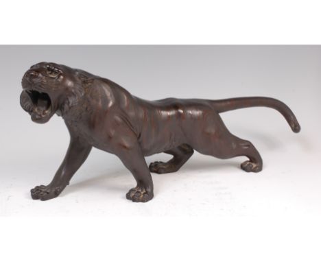 A Japanese Meiji period bronze tiger, naturalistically modelled in roaring stance, with textured markings, signed verso, 52cm