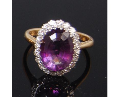 A ladies 18ct gold and platinum, amethyst and diamond set dress ring, arranged as a large oval cut amethyst in a surround of 