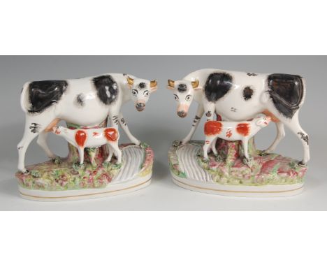 A pair of late Victorian Staffordshire groups,  each modelled as a Friesian cow with calf on a naturalistic base, each with s