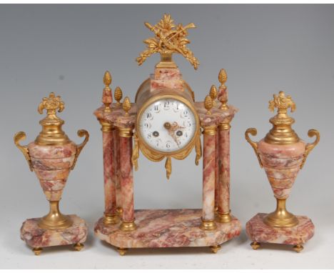 A circa 1900 French rouge marble and gilt metal mounted three piece clock garniture, the portico type six column clock having