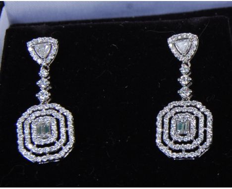 A pair of contemporary ladies 18ct white gold and diamond set ear pendants, each drop with a centre claw set small baguette, 