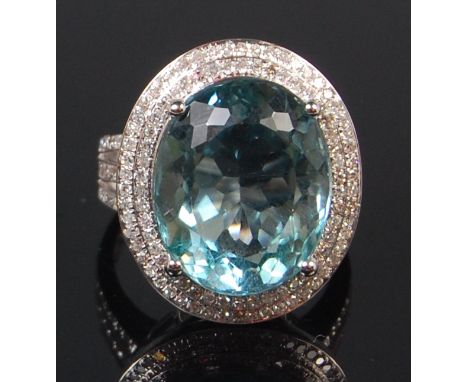 A contemporary 14ct white gold blue topaz and diamond cocktail ring, the oval cut topaz weighing approx 11.3ct, within a two 