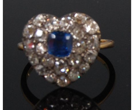 A circa 1900 ladies sapphire and diamond ring, arranged as an antique cushion cut sapphire within a double heart surround of 