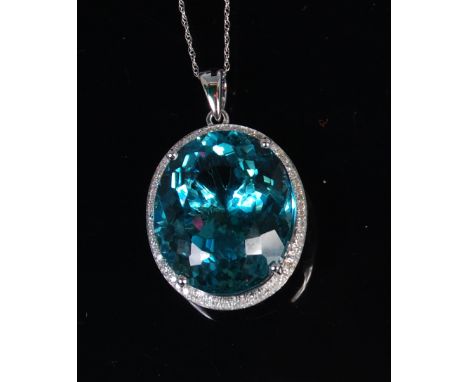 A modern 14ct white gold topaz and diamond set pendant, the huge oval cut topaz weighing approx 24ct, within a surround of sm