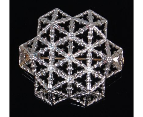 A modern 18ct white gold and diamond set snowflake brooch, of openwork convex form, centre set with a raised brilliant weighi