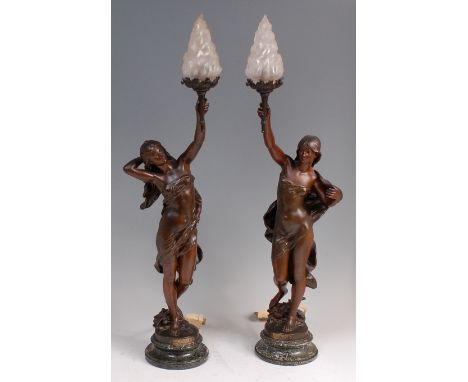 After Moreau - Pair; La Fable and La Vérité, bronzed spelter figural lamps, each cast as robed maidens, the moulded glass sha