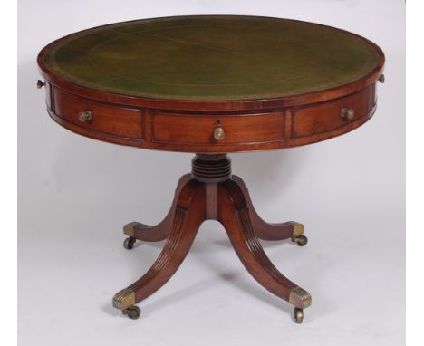 A Regency mahogany pedestal drum table, having a gilt tooled green leather inset writing surface above four real and four dum