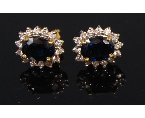 A pair of 18ct gold sapphire and diamond set oval cluster ear studs, the four claw set oval cut sapphires each weighing appro